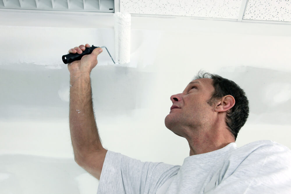commercial painters Brisbane painting the ceiling with a paint roller 